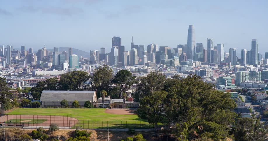 Baseball field on a hill and a metropolis in the background