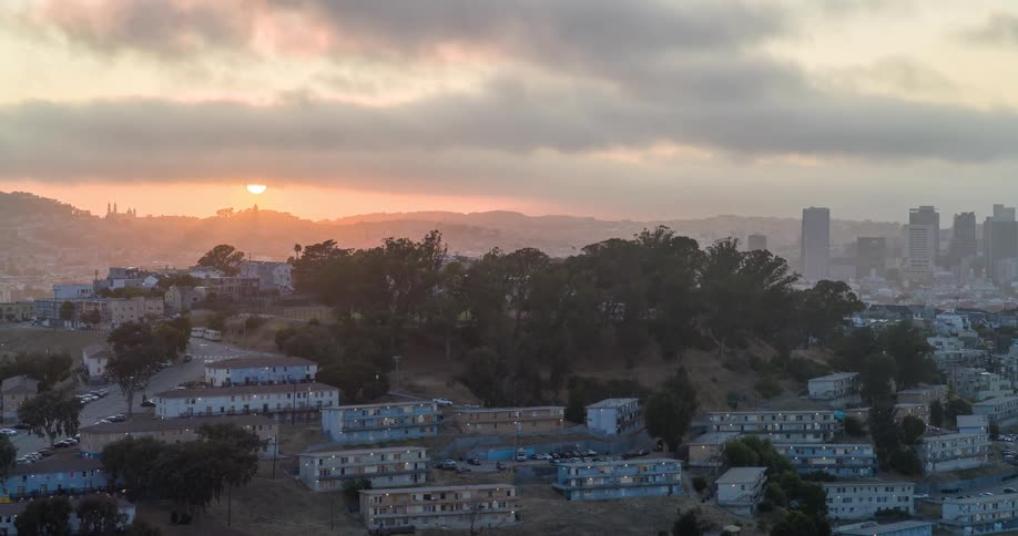 A residential area with a series of highrise apartment buildings on a cloudy day at sunset