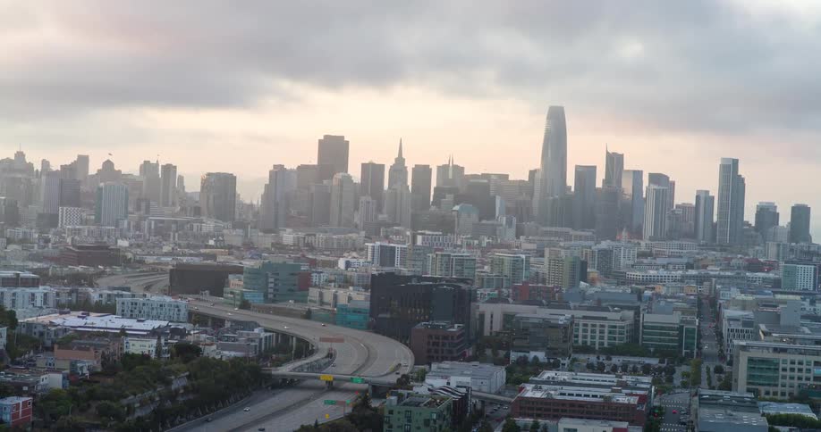 Metropolis with skyscrapers and a highway in the foreground on a cloudy day
