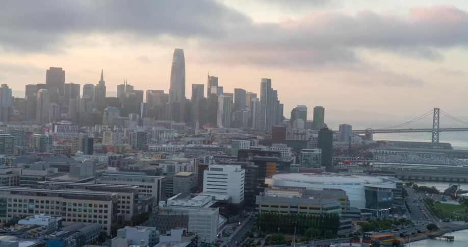 A city skyline view on a cloudy day features a series of highrise and skyscraper buildings