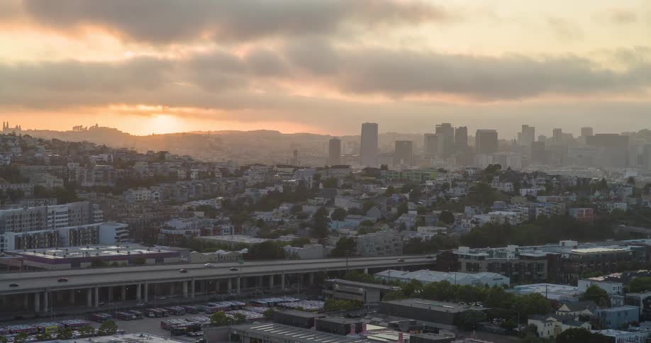 The sun is rising on the fog filled city