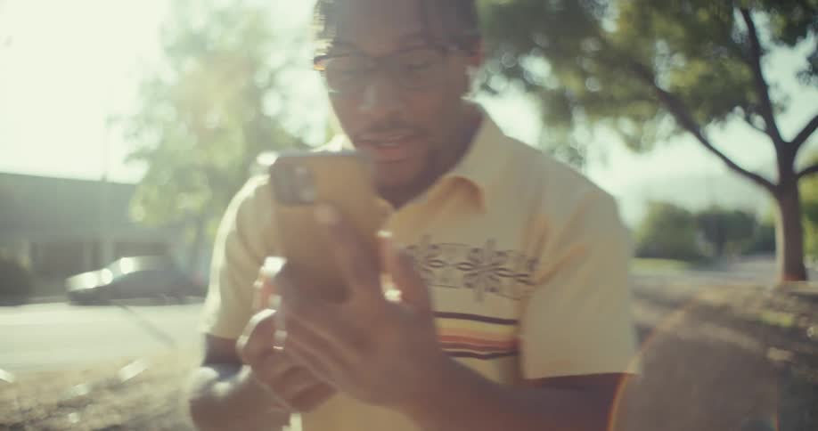 Happy celebrating man holding a smartphone in an outdoor environment