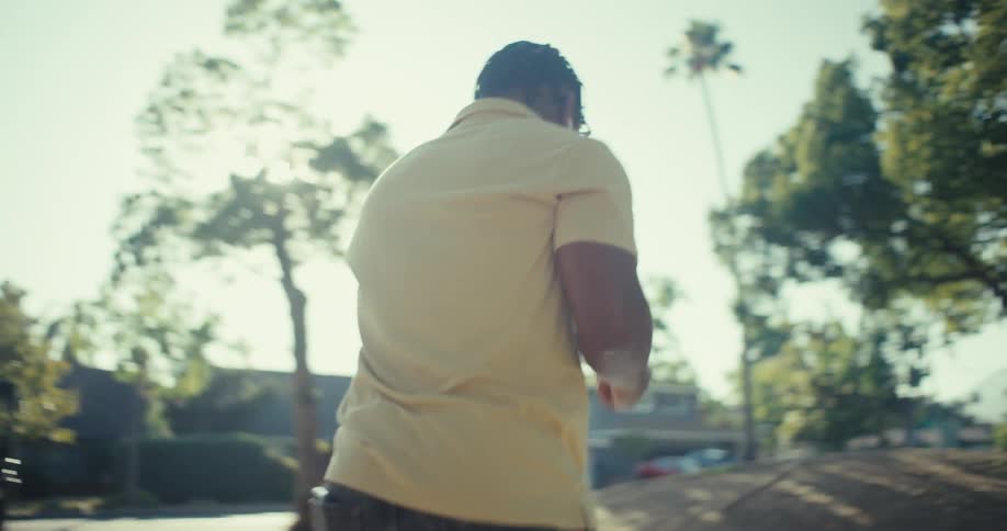 A man is walking in town on a sunny day