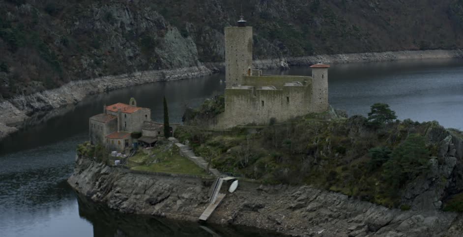 The shoreline has some stone buildings on a hill