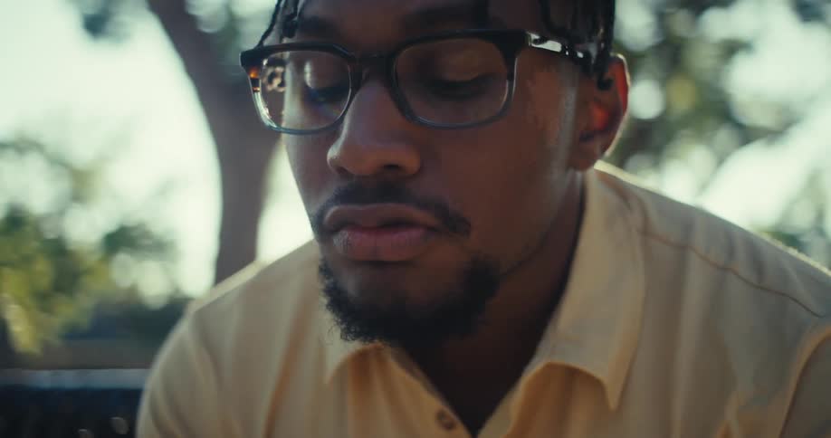Man with glasses sitting outdoors