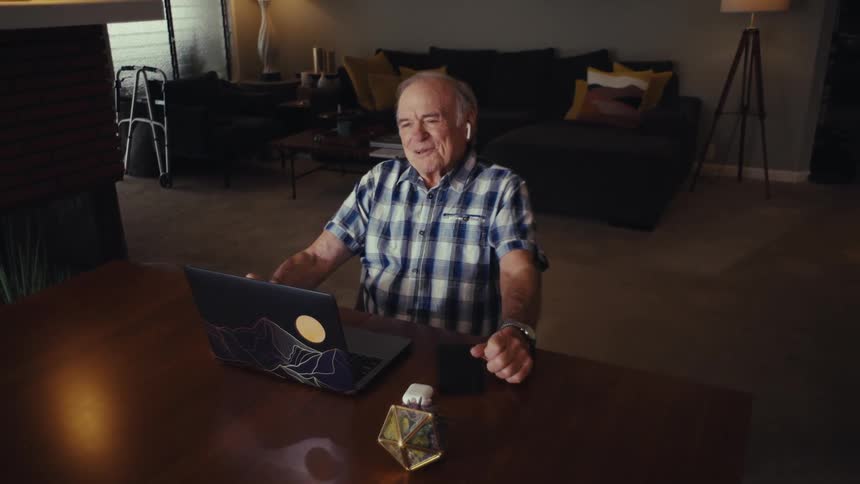 A man on video call laughing happily while having a conversation