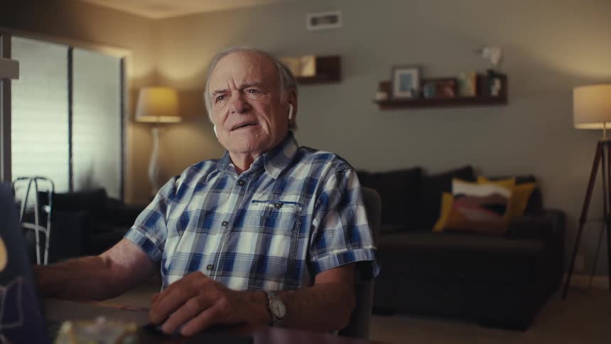 Elderly man sitting in front of a laptop and sending the expression suddenly