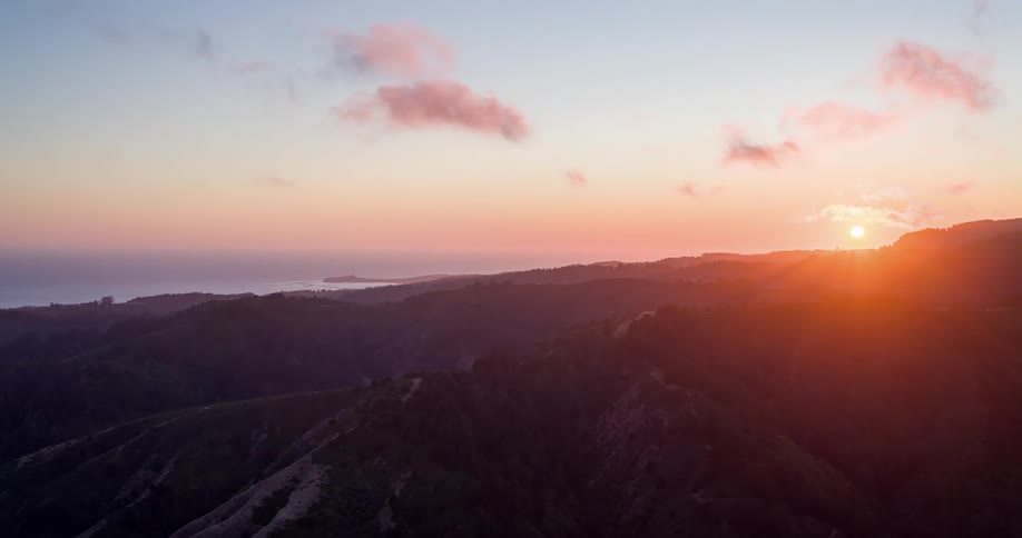 Sun setting on the horizon over the mountain ridge