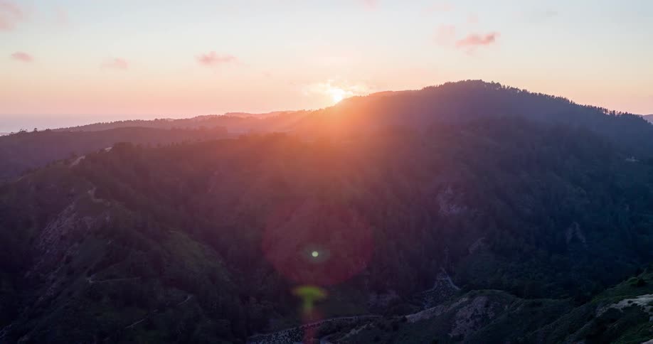 Aerial view of a treecovered mountain range under a sunrise