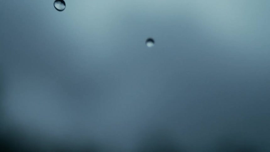 Raindrops falling against a blurred bluegray stormy background
