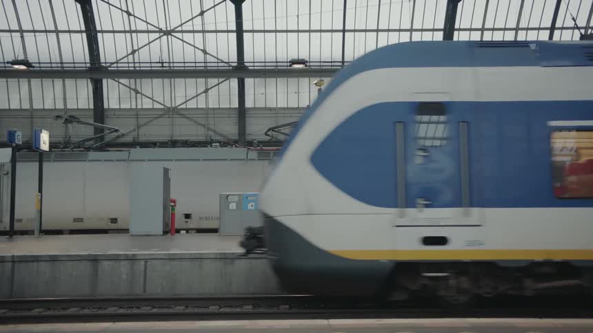 A passenger train drives through a train station