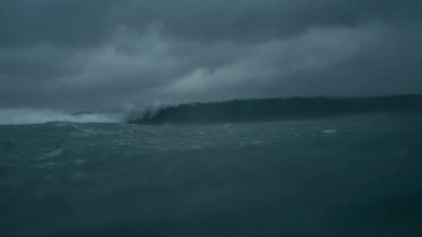Dark choppy ocean water under a heavily overcast sky waves with whitecaps are visible in the distance and the overall scene conveys a strong possibly stormy marine environment