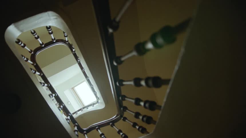 Sunshine filters from a window down a spiral staircase