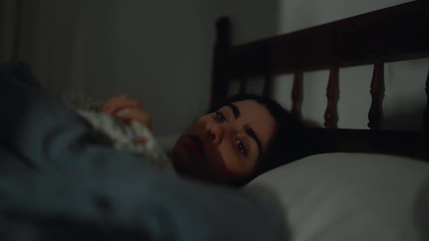 The girl is laying awake in bed