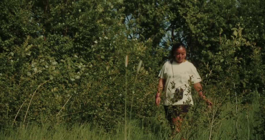 Woman walking through a natural environment with trees around