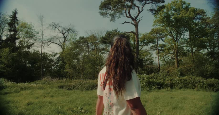 Woman walking in a corner with trees in the background during the day