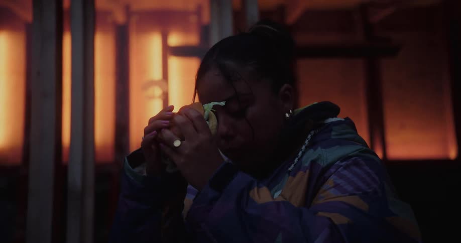 Woman indoors eating a sandwich