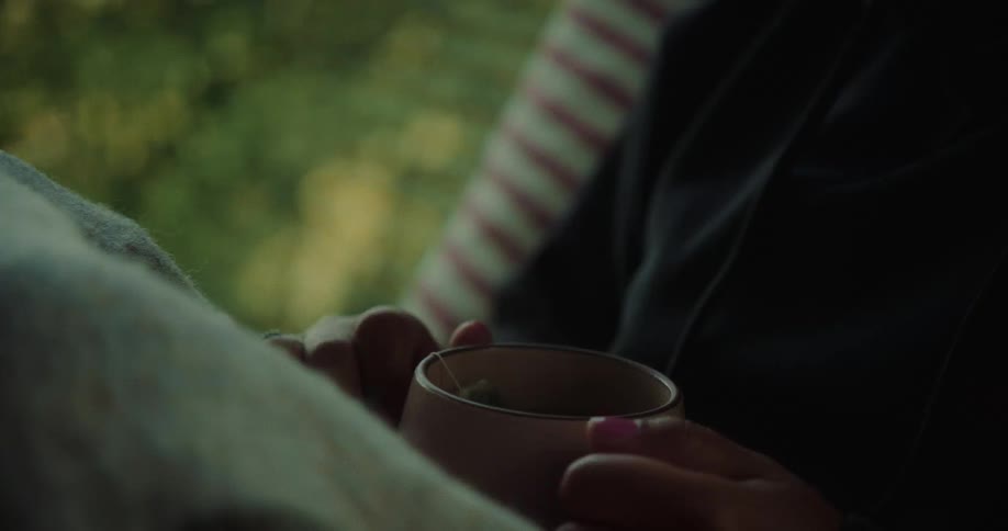 Pair of hands of a person holding a cup
