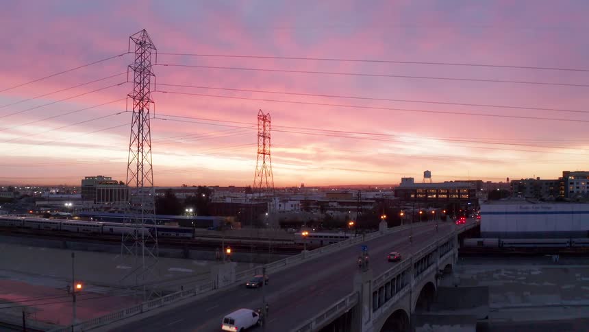 Viaduct above a canal with vehicle traffic on a red sky morning