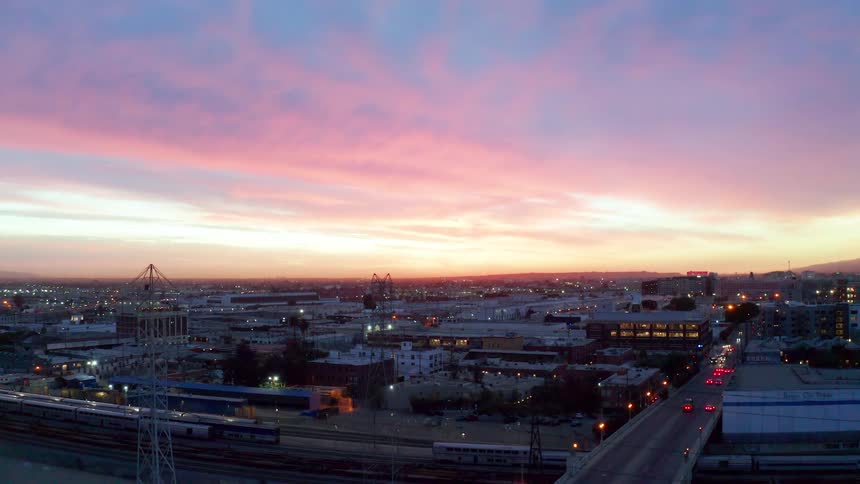 The cars drive toward the city at sunset