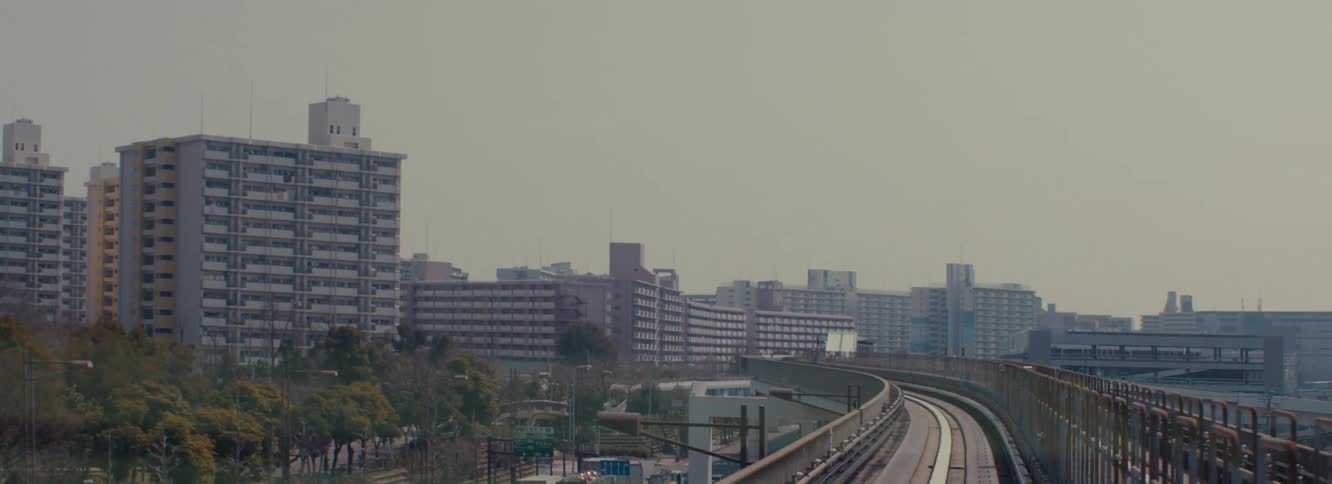 A front seat view of a metro in osaka japan showing the urban skyline