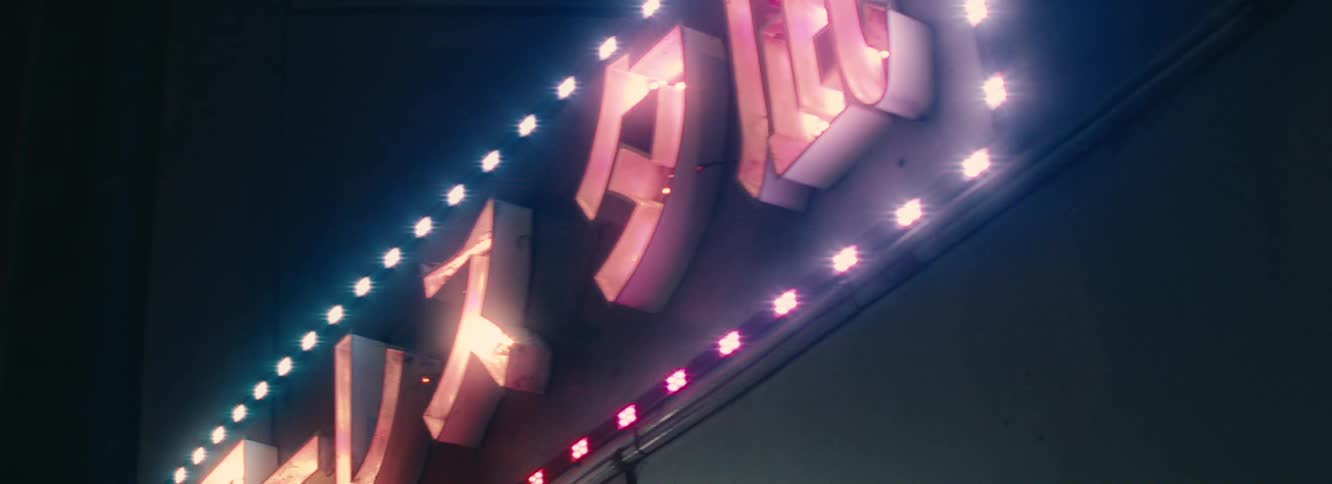 A closeup of a neon sign with japanese characters illuminated by changing lights the lights cycle through vibrant colors like pink blue yellow and white creating a dynamic visual effect against the dark background