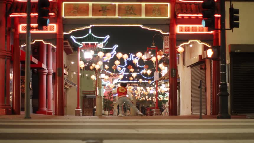 A young man dances downtown across a busy street