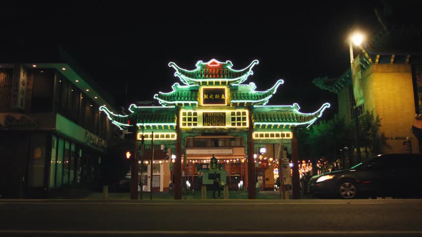 Street with vehicle traffic at night and in the background illuminated classical asian architecture