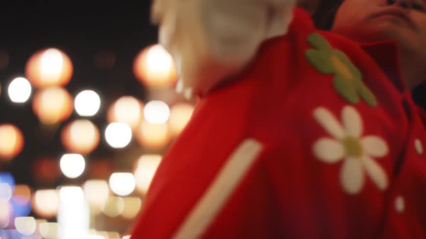 An Asian teen dances in a street at night