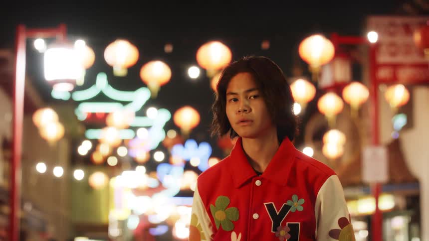 Young man with a red jacket in an urban environment at night