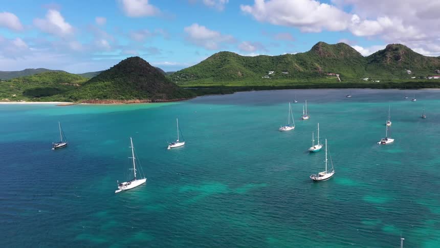 Boats and yachts in a turquoise sea in the archipelago with mountains in the background