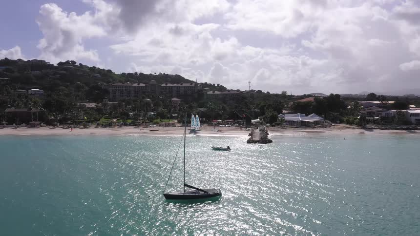 Static boat in an ocean with a city in the background on the shore