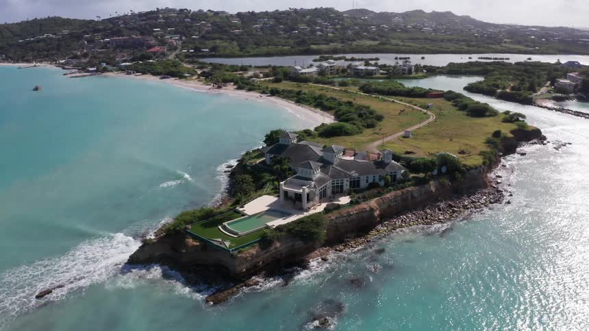 A large mansion is on the shore of the small island