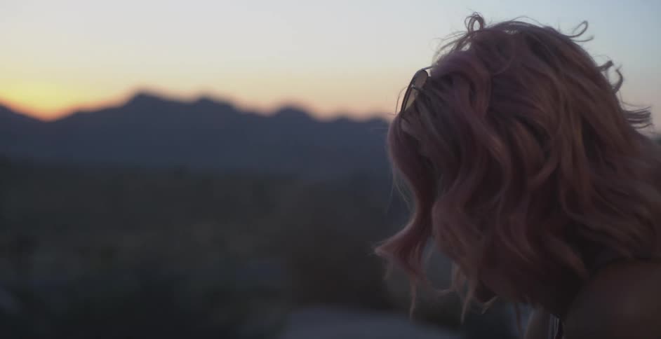 Woman with hair moving by the force of the wind in a natural setting in the mountains