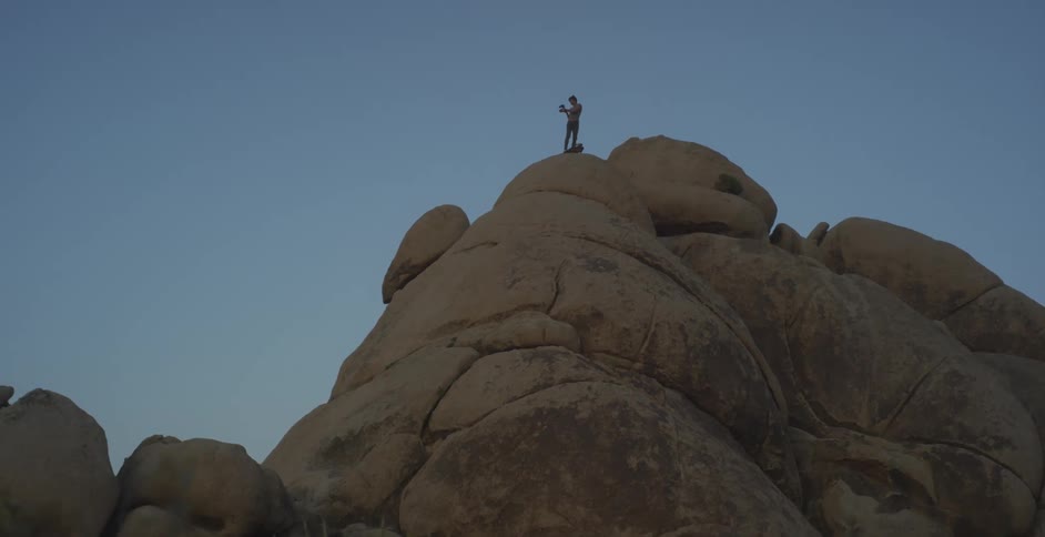 Person on a rocky peak in an outdoor setting
