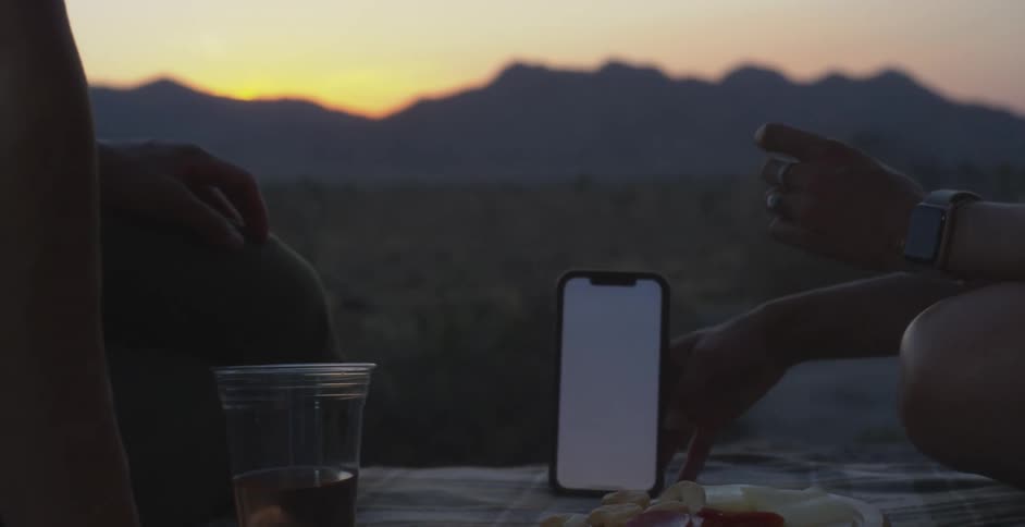 Person holding a smartphone and talking to another person
