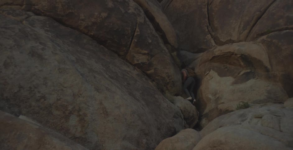 Person walking between narrow rocks