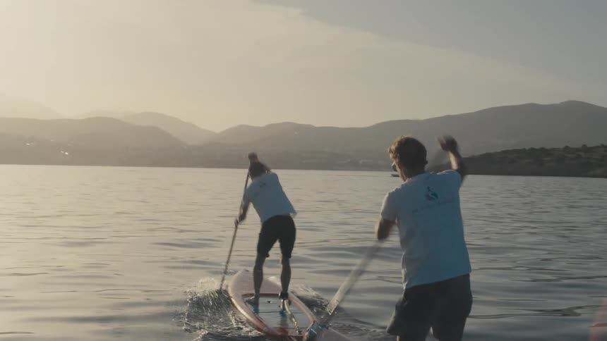 Two men practicing stand up paddle in the sea