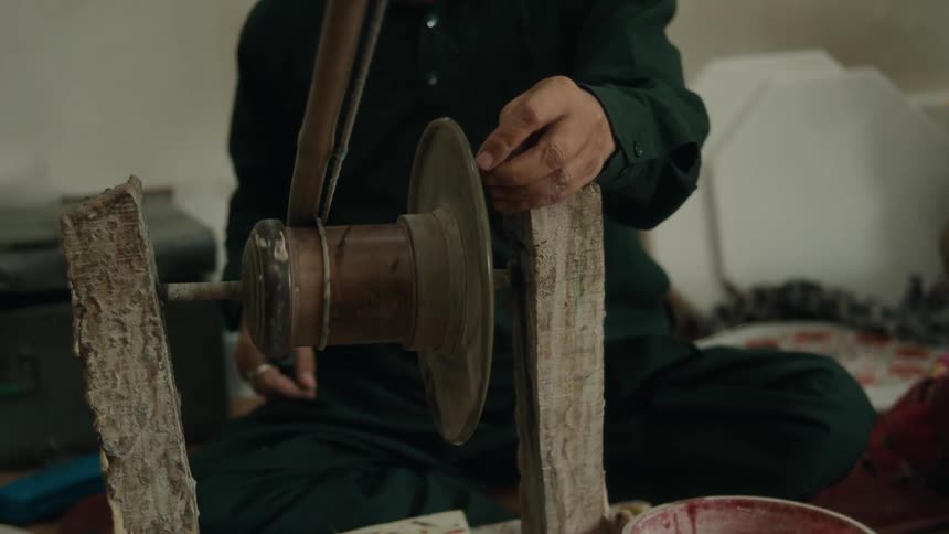 Pair of hands of a person in an indoor space handling a hand tool