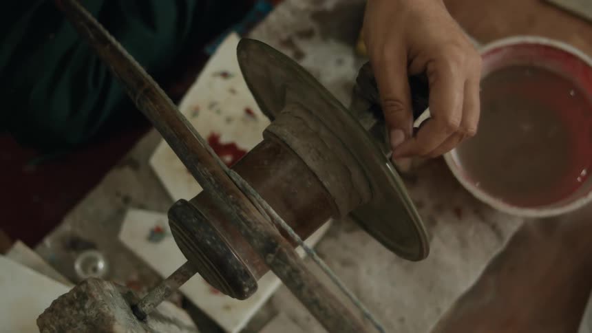 A person is doing artwork using a spinning tool