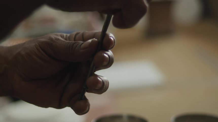 A person is holding two metal sticks