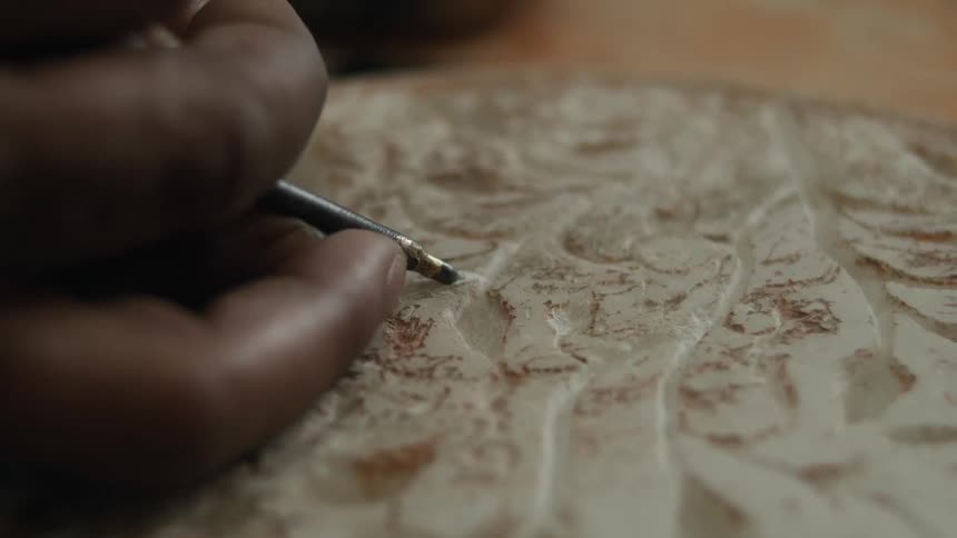 A tool is being used to carve a design