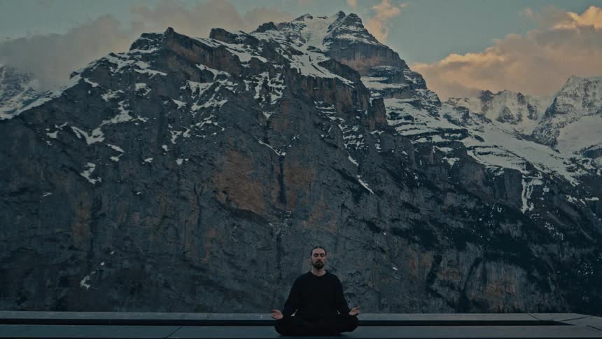 A man meditates in front of a mountain