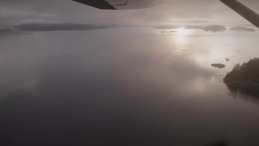 The plane glides over the water by the islands