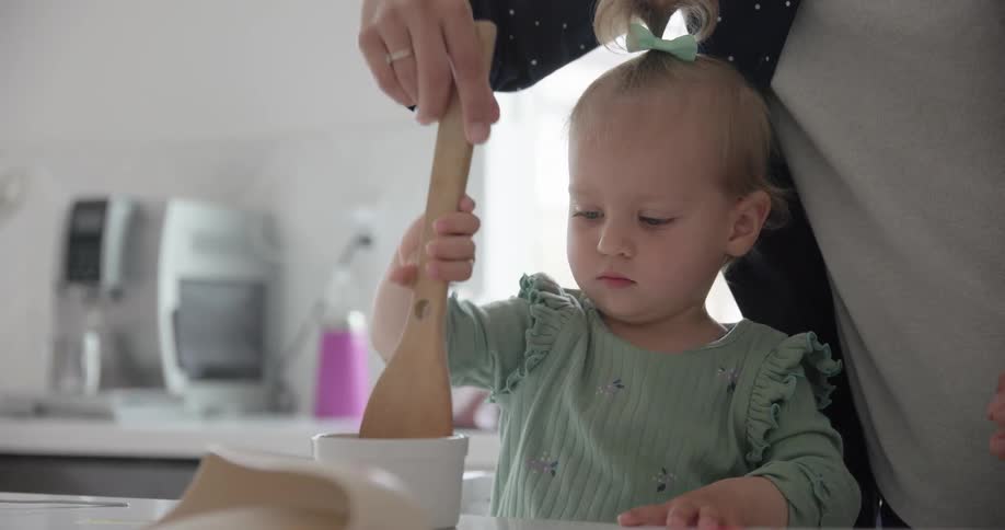 A mother and daughter cook together in the kitchen