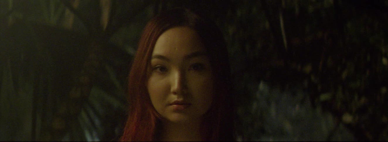 The woman is standing in the forest