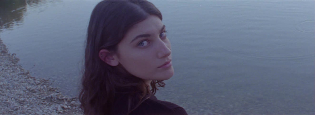 A woman looks back by the lake