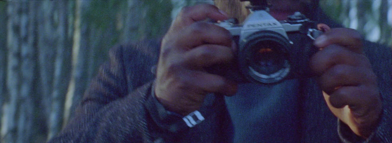 Man using a professional camera in a forest environment