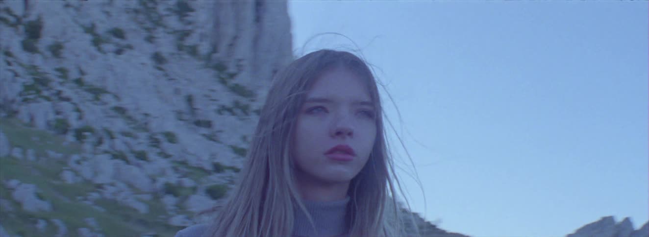 The girl looks around by the mountains