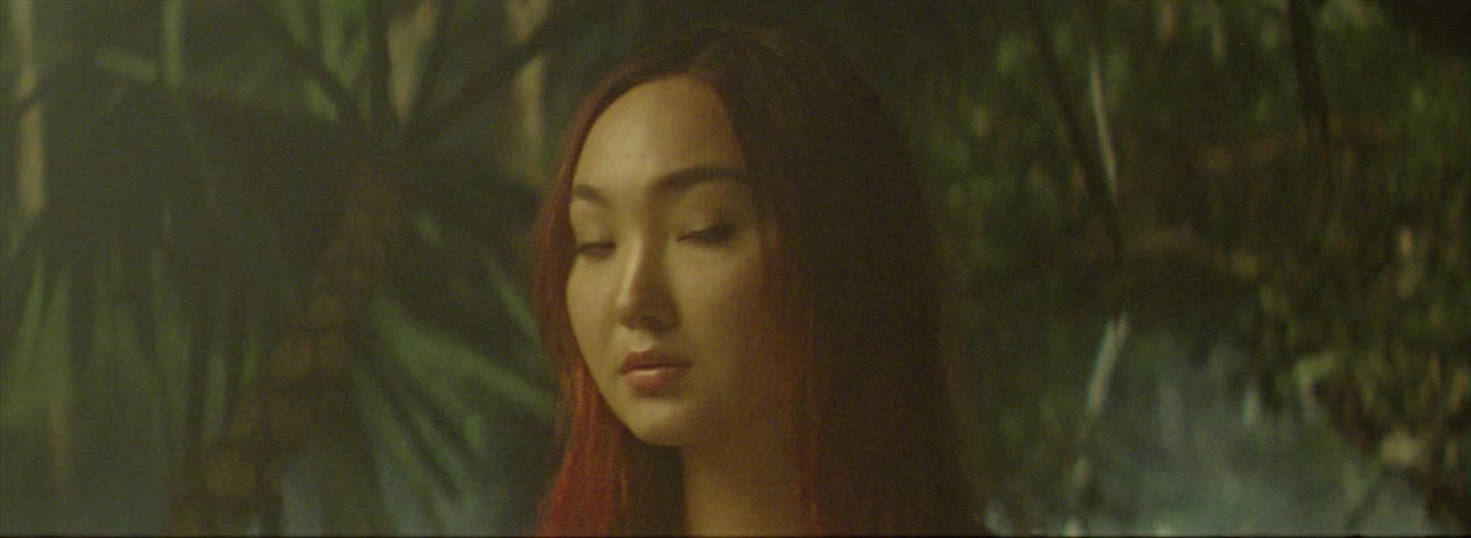 A woman stands in a lush jungle